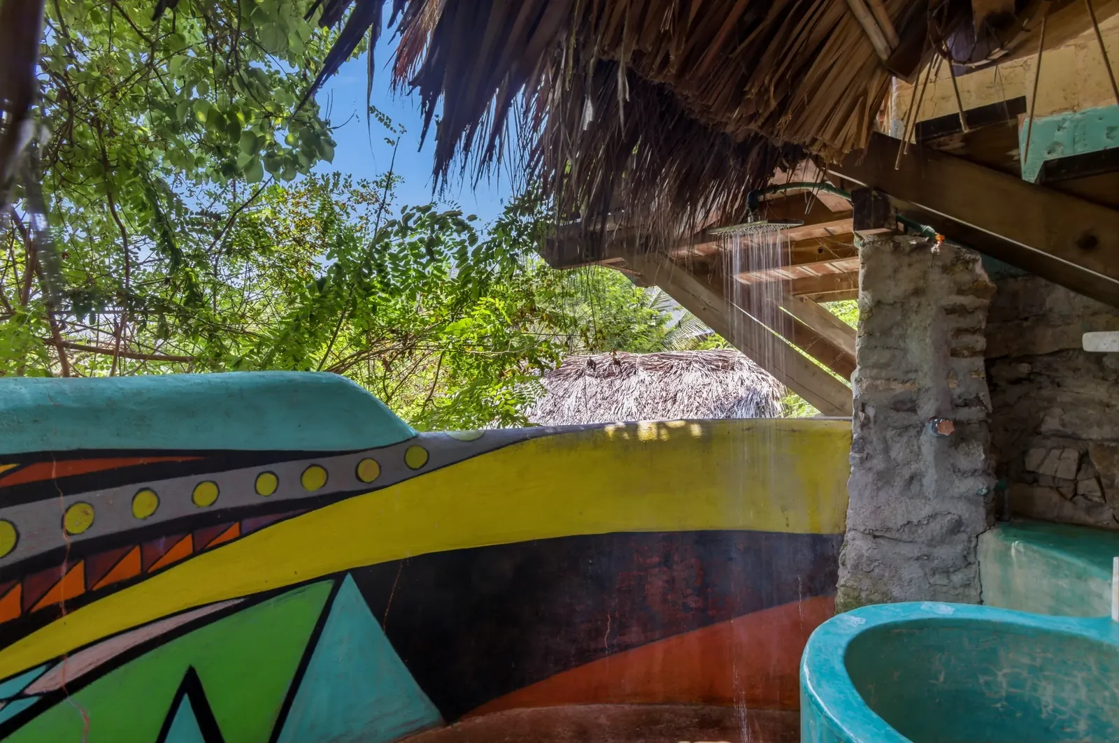 Open-air rain shower against painted Oaxacan walls
